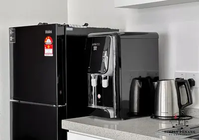 a kitchen with a coffee maker and a black refrigerator at Urban Suites by Simply Penang in Jelutong