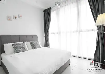 a bedroom with a large white bed with windows at Urban Suites by Simply Penang in Jelutong