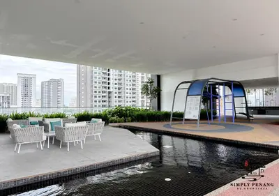 a building with a swimming pool with chairs and ailion at Urban Suites by Simply Penang in Jelutong
