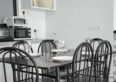 a kitchen with a table with chairs and a microwave at Urban Suites by Simply Penang in Jelutong