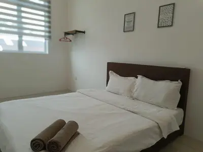a white bed with two rolled up towels on it at Cozy 4 bedrooms House by Mr Homestay, 3 mins to Kulim Landmark Centre in Kulim