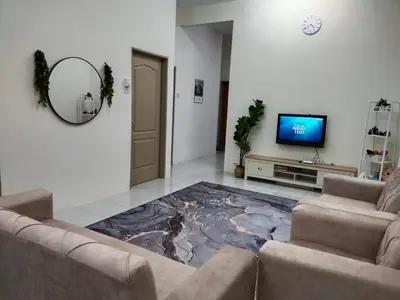 a living room with a couch and a tv at WAFID HOMESTAY 2 SERI ISKANDAR in Seri Iskandar