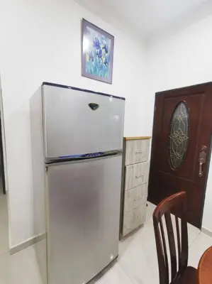 a refrigerator in a kitchen with a table and a chair at Ipoh stadium-18 pax (mahjong/5min to town) pets friendly in Ipoh