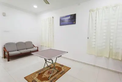 a living room with a table and a couch at Ipoh stadium-18 pax (mahjong/5min to town) pets friendly in Ipoh