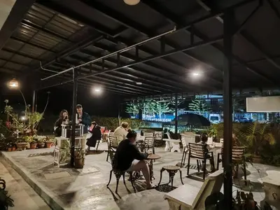 a group of people sitting in a patio at night at Rovers Inn Guesthouse - Age 11 And Above Only in Tanah Rata