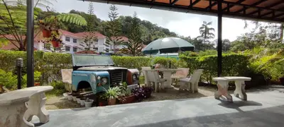 a patio with a table and chairs and an umbrella at Rovers Inn Guesthouse - Age 11 And Above Only in Tanah Rata