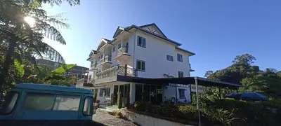 a building with a van parked in front of it at Rovers Inn Guesthouse - Age 11 And Above Only in Tanah Rata