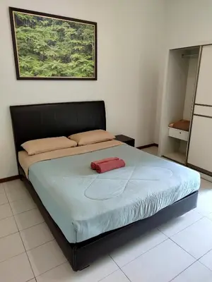 a bedroom with a bed with a red towel on it at Rovers Inn Guesthouse - Age 11 And Above Only in Tanah Rata