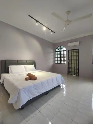 a bedroom with a large bed with white sheets and a ceiling at Ipoh Tambun Sunway 5 Rooms Spacious Homestay in Tambun