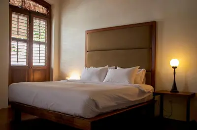 a bedroom with a large bed with white sheets and pillows at Ren I Tang Heritage Inn in George Town