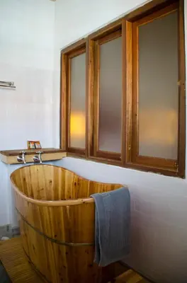 a wooden bath tub in a bathroom with windows at Ren I Tang Heritage Inn in George Town