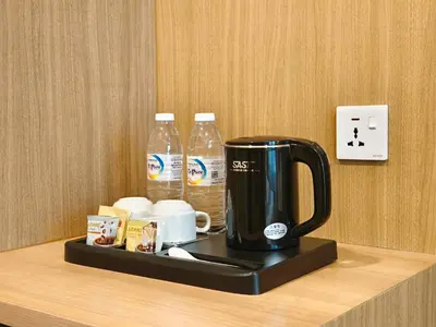 a coffee maker on a counter with two bottles of water at ZOOM HOTEL in George Town
