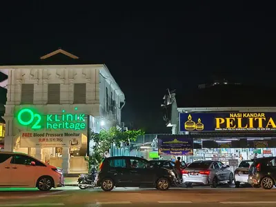 a group of cars parked on a city street at night at ZOOM HOTEL in George Town