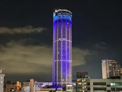 a tall building is lit up in purple at ZOOM HOTEL in George Town