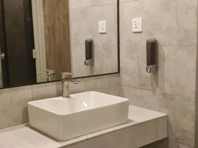 a white sink in a bathroom with a mirror at ZOOM HOTEL in George Town