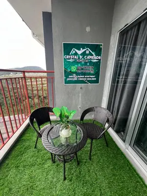 a table and two chairs on a balcony at CRYSTAL D CAMERON HOMESTAY in Cameron Highlands