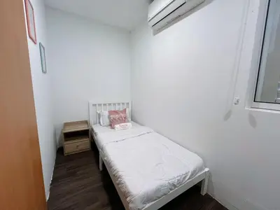 a small white room with a small bed in it at Penang Heritage Home in George Town