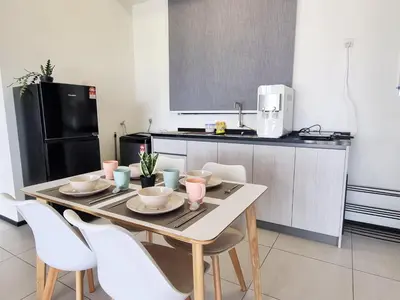 a kitchen with a table and chairs in a kitchen at Modern Elegance Suite, 5 to 6 pax at Urban Suites Georgetown by SuperStay in Jelutong