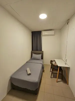 a small room with a bed and a table at SS HOSTEL PENANG in George Town