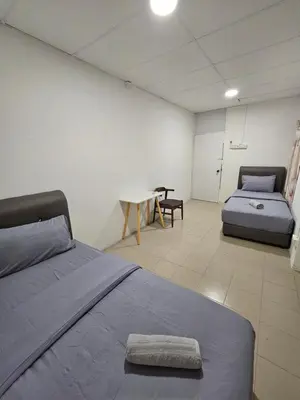 a bedroom with two beds and a table in it at SS HOSTEL PENANG in George Town