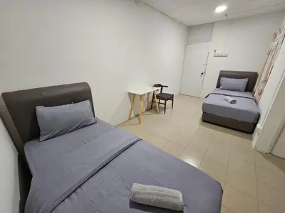 a room with two beds and a table with a chair at SS HOSTEL PENANG in George Town