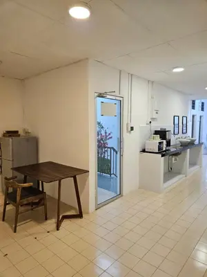 a room with a table and a kitchen with a door at SS HOSTEL PENANG in George Town