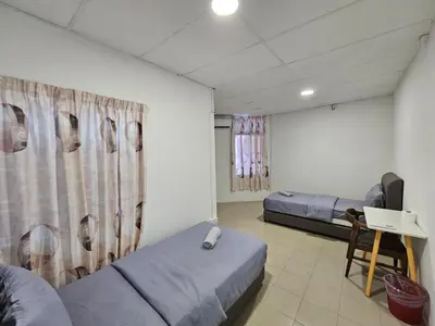 a room with two beds and a table in it at SS HOSTEL PENANG in George Town