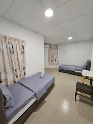 a bedroom with two beds and a table and a chair at SS HOSTEL PENANG in George Town
