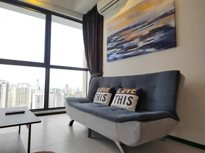 a living room with a couch with two pillows on it at Seaview Infinity Pool #6pax #2bedroom #2bathroom in Jelutong