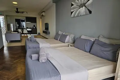 a room with three beds and a living room at Deluxe Seaview Suite Twin Bed by The Only Bnb in Tanjong Tokong