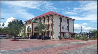 a building with cars parked in a parking lot at Nahdhoh Hotel in Kubang Semang