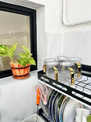 a shelf with pots and a mirror and scissors at Sarah homestay Muslim Permatang Pauh in Permatang Pauh