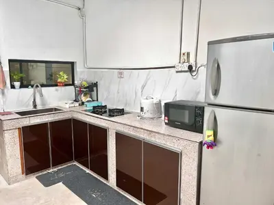 a kitchen with a refrigerator and a microwave at Sarah homestay Muslim Permatang Pauh in Permatang Pauh