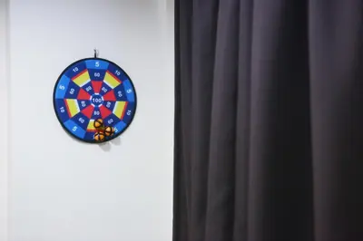 a dart board on a wall next to a curtain at Private GameRoom and Cinema at The CEO Penang in Bayan Lepas