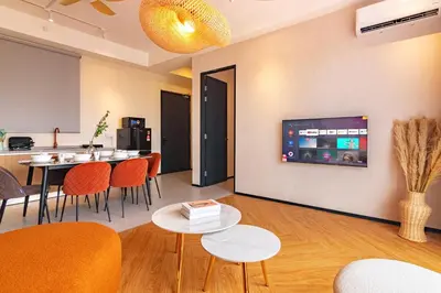 a living room with a table and chairs and a tv at Urban Suites, Signature Collection by Stellar ALV in Jelutong