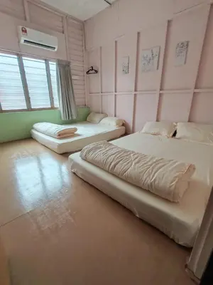 two beds in a room with pink walls at Grandpa House \u7237\u7237\u8001\u5bb6 in Gopeng