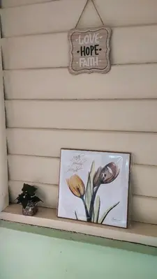a picture of flowers on a shelf with a sign at Grandpa House \u7237\u7237\u8001\u5bb6 in Gopeng