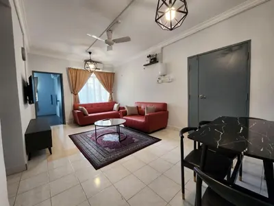 a living room with a red couch and a table at Thetamu Homestay مسلم Pesona in Jalan Baharu