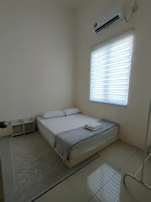 a white bedroom with a bed and a window at Rana Homestay Ipoh Perak in Tanjung Rambutan