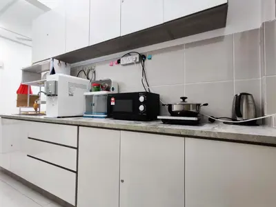 a kitchen with white cabinets and a black microwave at Hygge Living Kampar II (Near UTAR) in Kampar
