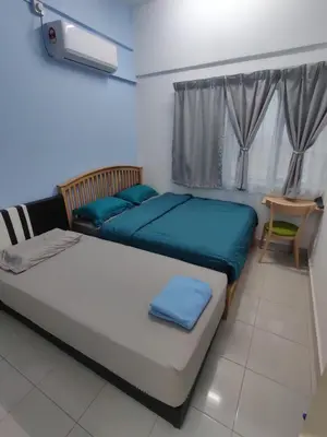 a bedroom with two beds with blue sheets and a table at Hygge Living Kampar II (Near UTAR) in Kampar