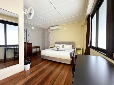 a bedroom with a bed and a table in it at Madras Inn 58-1 in George Town