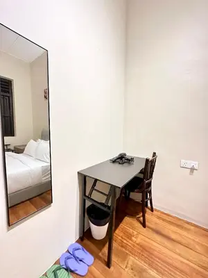 a room with a table and a mirror and a bed at Madras Inn 58-1 in George Town