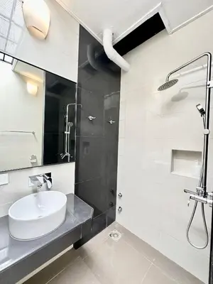 a white bathroom with a sink and a shower at Madras Inn 58-1 in George Town