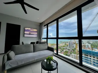 a living room with a couch and large windows at Cozy Urban Suites Georgetown View by 3C in Jelutong