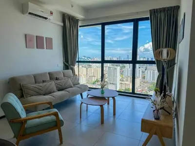 a living room with a couch and a large window at Cozy Urban Suites Georgetown View by 3C in Jelutong