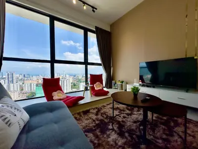 a living room with a large tv and large windows at Cozy Urban Suites Georgetown View by 3C in Jelutong