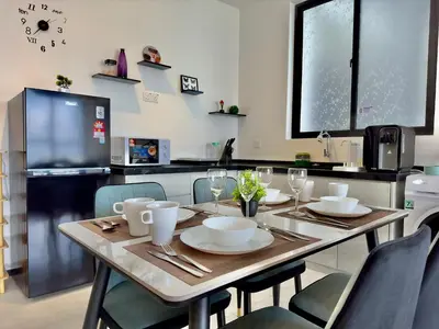 a kitchen with a table with chairs and a television at Cozy Urban Suites Georgetown View by 3C in Jelutong