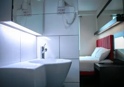 a white bathroom with a sink and a bed at Hotel Regal Vista in Ipoh