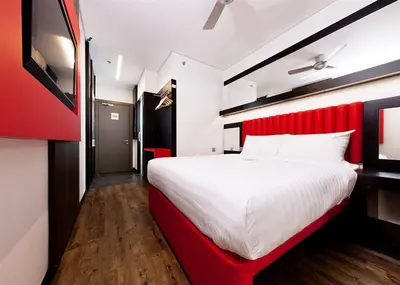 a bedroom with a large bed with a red headboard at Hotel Regal Vista in Ipoh
